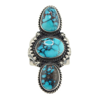 The “Twin Spirits” Revival Ring by Derrick Gordon (Navajo) is a silver ring with three oval turquoise stones, dark veining, ornate bezels, and twisted rope detailing around each stone.