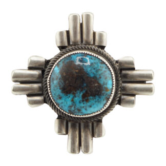 A silver brooch with a round, blue and black turquoise stone in the center, framed by a twisted silver border and surrounded by four groups of parallel silver bars arranged in a cross shape.