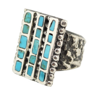 A silver ring with a wide, textured band and a rectangular face featuring vertical rows of turquoise inlays set in a geometric pattern.