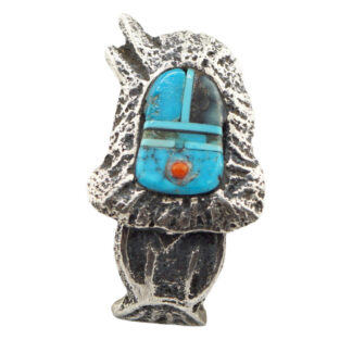 The Yei’ be’ Chei’ Inlay Ring by Lester James (Navajo) is a silver ring with a textured, irregular design, featuring an inlaid turquoise stone, a small round red-orange accent, and thin black lines.