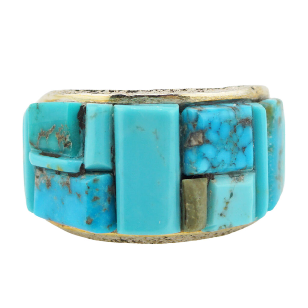 A chunky ring featuring a mosaic of rectangular and square turquoise stones set in a thick, silver-toned band. The turquoise displays varying shades of blue with natural brown veining.