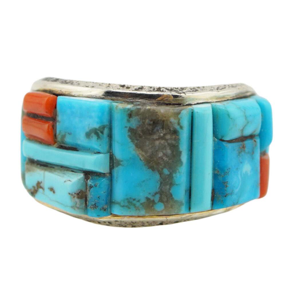 A silver ring featuring inlaid turquoise and coral stones arranged in a geometric pattern, showcasing vibrant blue and red colors with natural stone textures.