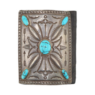 Ornate silver belt buckle with engraved patterns and five turquoise stones set in the center and corners, displayed against a white background.